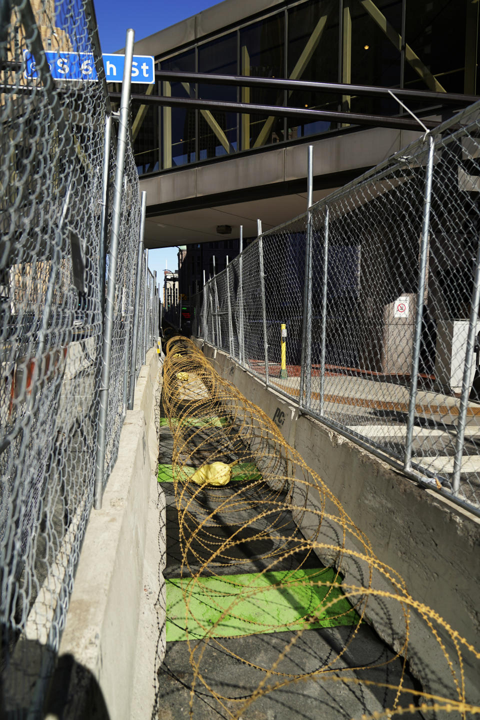 Concertina wire sits between fenced barriers outside the Hennepin County Government Center, Wednesday, Feb. 23, 2021, in Minneapolis, as part of security in preparation for the trial of former Minneapolis police officer Derek Chauvin. The trial is slated begin with jury selection on March 8. Chauvin is charged with murder the death of George Floyd during an arrest last May in Minneapolis. (AP Photo/Jim Mone)