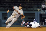 Los Angeles Dodgers' Chris Taylor, right, steals second base past San Francisco Giants third baseman Wilmer Flores during the fifth inning of a baseball game Wednesday, July 21, 2021, in Los Angeles. (AP Photo/Marcio Jose Sanchez)