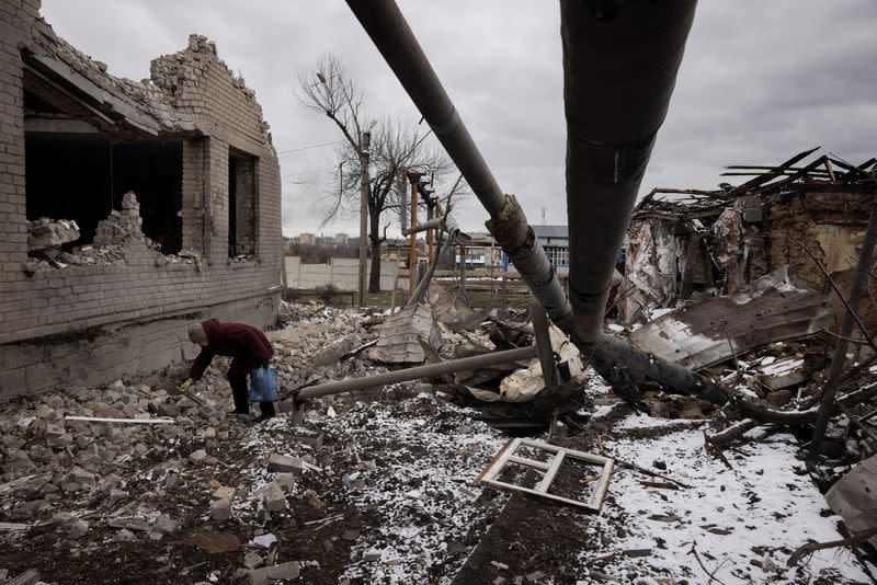 Nadezhda Prokopenko clears debris in the yard of the house of a relative that was destroyed in a Russian missile strike in Selydove near Avdiivka