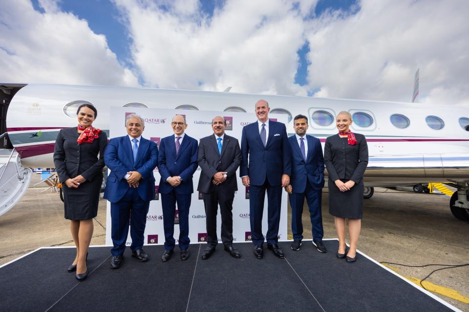 Qatar Airways CEO with cabin crew and other Qatar and Gulfstream executives standing in front of the G700.