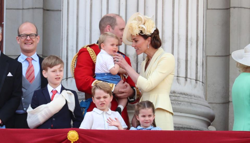 Kate fussing with Prince Louis.