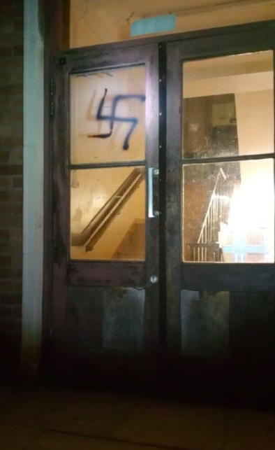 <em>A door was spray-painted with the Nazi symbol (PA)</em>