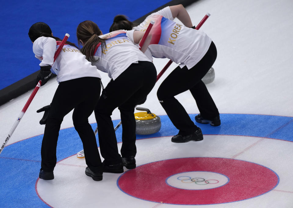 South Korea's team, sweep the ice, during the women's curling match against Canada, at the 2022 Winter Olympics, Thursday, Feb. 10, 2022, in Beijing. (AP Photo/Nariman El-Mofty)