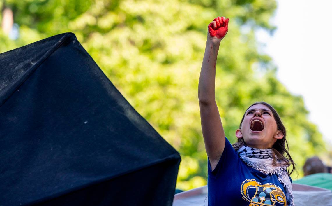 A demonstrator raises a fist to the sky during a pro-Palestinian protest at an encampment at UNC-Chapel Hill on Monday, April 29, 2024. Students for Justice in Palestine urged students to join the encampment, saying that university officials had told them that the “tents are coming down tonight.”