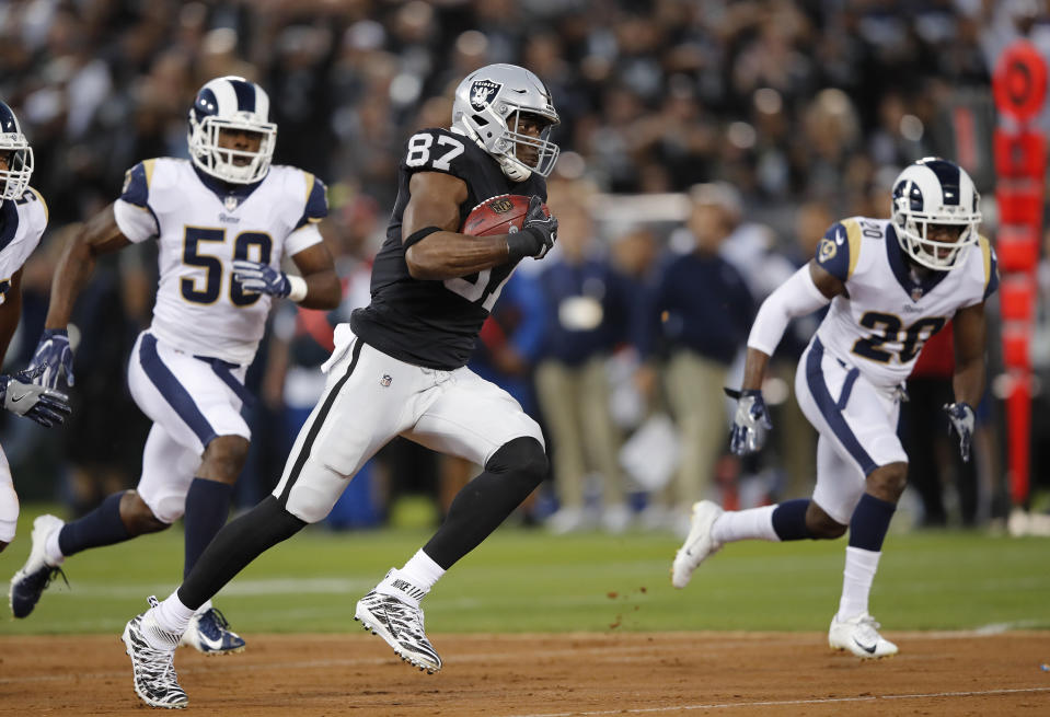 Oakland Raiders tight end Jared Cook runs with the ball past Los Angeles Rams linebacker Samson Ebukam, left, and defensive back Lamarcus Joyner (20) during the first half of an NFL football game in Oakland, Calif., Monday, Sept. 10, 2018. (AP Photo/John Hefti)