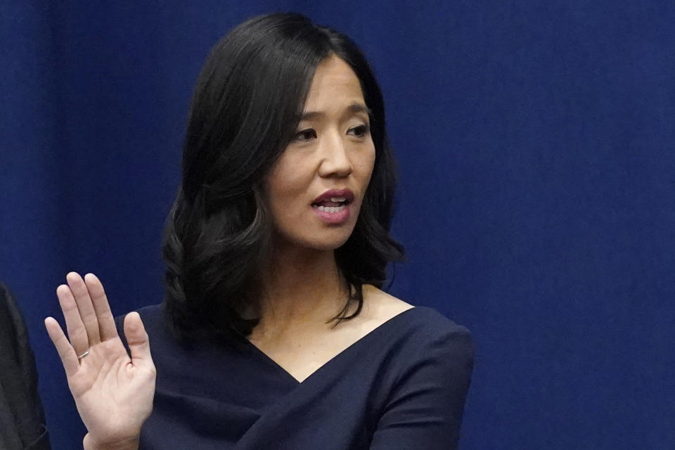 Michelle Wu raises her hand as she is sworn in as mayor.