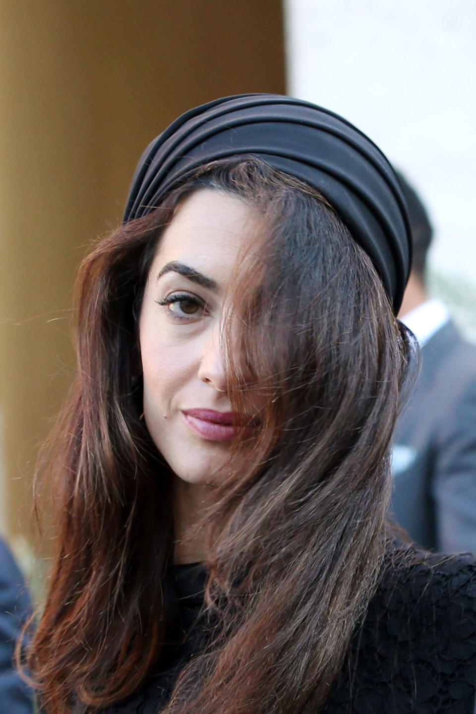 Amal se dejó la melena suelta y muy natural cubriendo su cabeza con un sombrero de inspiración árabe que le sentaba de maravilla por sus rasgos exóticos. El complemento era ideal para un look elegante y clásico al que daba un toque cultural y refinado.