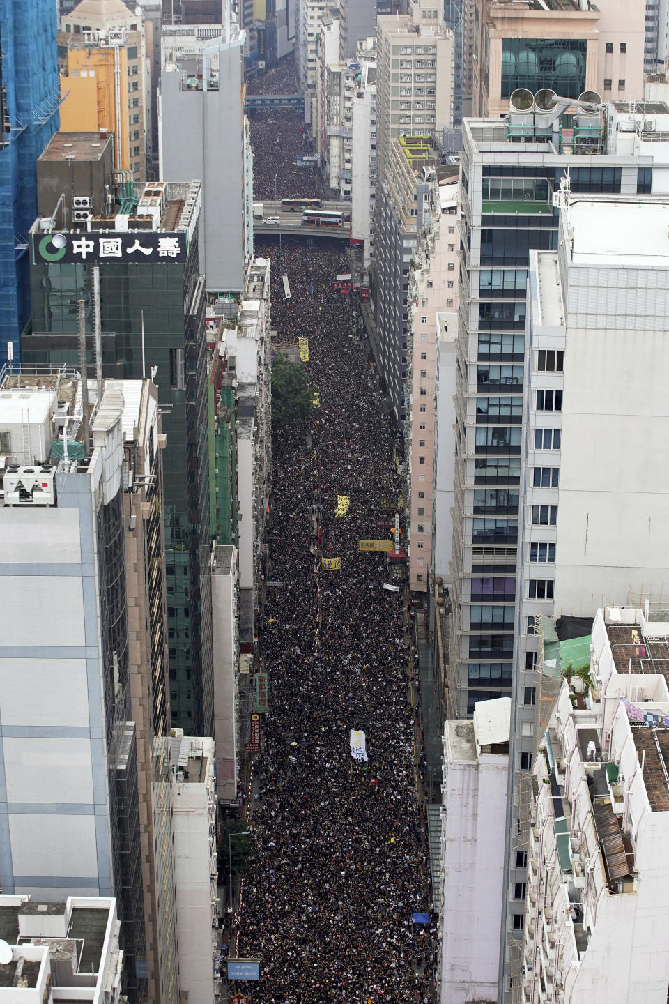 Tens of thousands of protesters carry posters and banners march through the streets as they continue to protest an extradition bill, Sunday, June 16, 2019, in Hong Kong. Hong Kong residents Sunday continued their massive protest over an unpopular extradition bill that has highlighted the territory's apprehension about relations with mainland China, a week after the crisis brought as many as 1 million into the streets. (Apple Daily via AP)