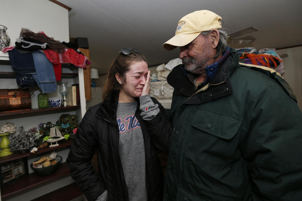 Abby McInnis, 19, cannot suppress her tears at the thought of how anticipated flood waters will affect the home of her grandfather Mark Harvey, right, at the Harbor Pines Mobile Home Community in Ridgeland, Miss., Friday, Feb. 14, 2020. Officials estimate the flooding along the Pearl River may be the worst in the area since 1983. (AP Photo/Rogelio V. Solis)