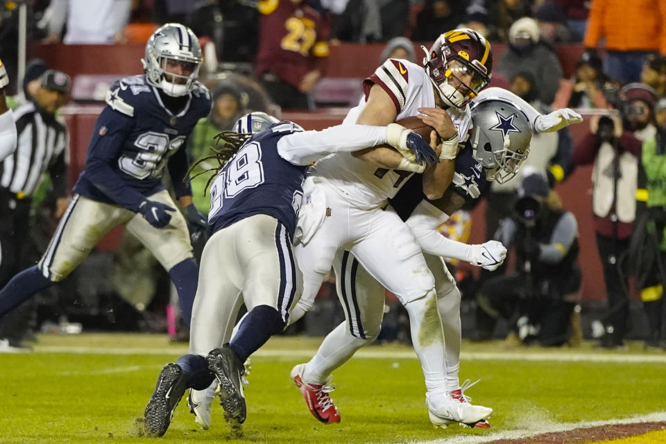 Washington Commanders quarterback Sam Howell (14) scores a touchdown against Dallas Cowboys safety Malik Hooker (28) and cornerback Trevon Diggs (7) during the second half an NFL football game, Sunday, Jan. 8, 2023, in Landover, Md. (AP Photo/Alex Brandon)