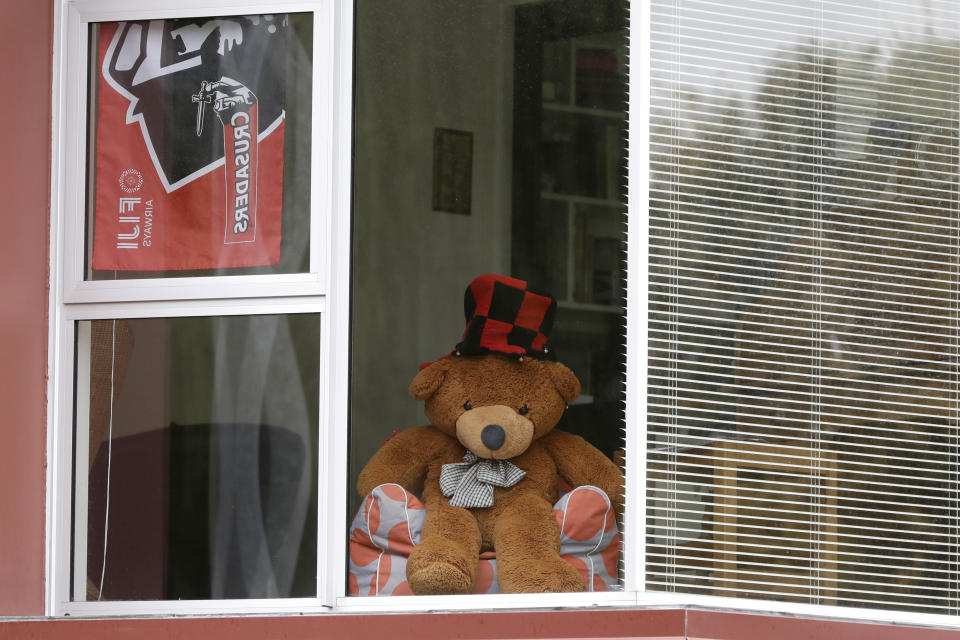 In this Sunday, March 29, 2020, photo, a teddy bear sits in a window of a house in Christchurch, New Zealand. New Zealanders are embracing an international movement in which people are placing teddy bears in their windows during coronavirus lockdowns to brighten the mood and give children a game to play by spotting the bears in their neighborhoods. (AP Photo/Mark Baker)