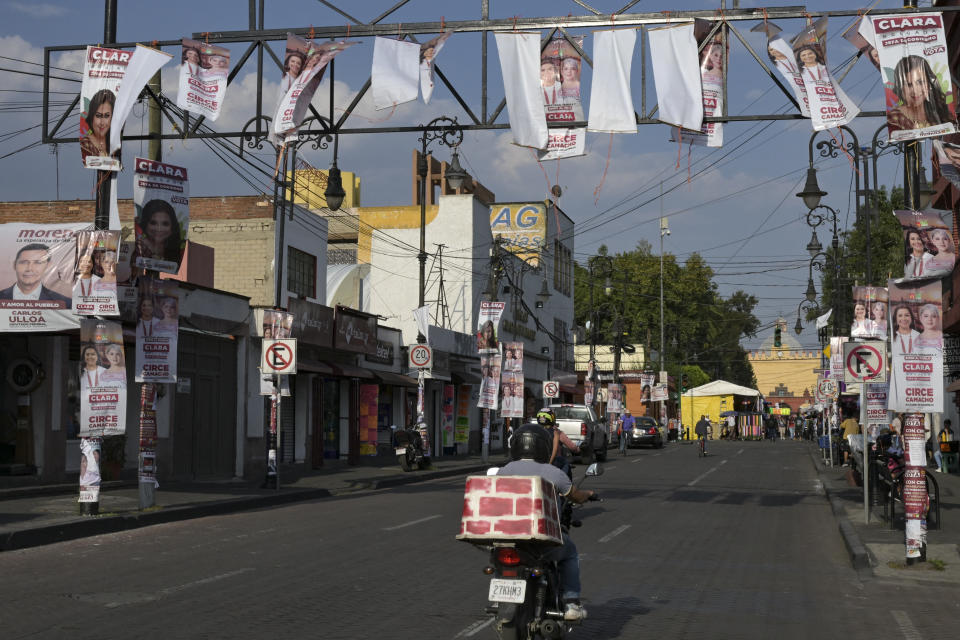A motorcyclist passes under a line of campaign signs in Xochimilco, Mexico, on May 31.