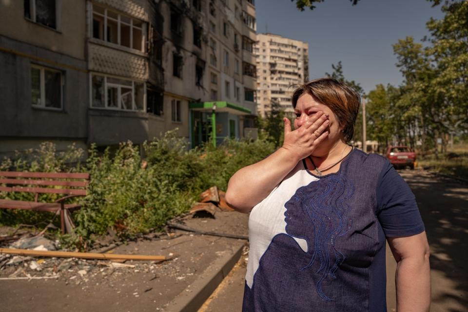 Svitlana llora junto a su departamento bombardeado en Saltivka (Bel Trew)