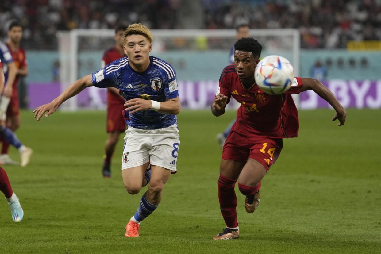 Japan's Ritsu Doan, left, and Spain's Alejandro Balde chase after the ball during Japan's win over Spain on Thursday.