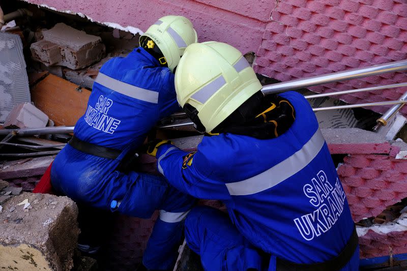 Ukrainian rescuers look for bodies under the rubble in Hatay, Turkey