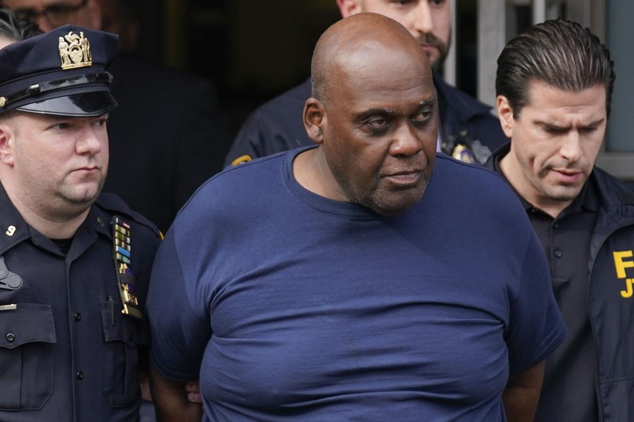 Law enforcement officials lead subway shooting suspect Frank R. James, 62, center, away from a police station in Manhattan, New York on Wednesday, April 13, 2022. 