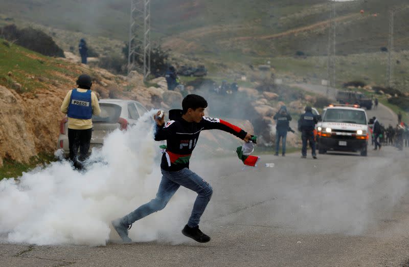 A Palestinian demonstrator hurls a tear gas canister fired by Israeli forces during a protest against Israeli settlements and Trump's Middle East peace plan, in Jordan Valley in the Israeli-occupied West Bank