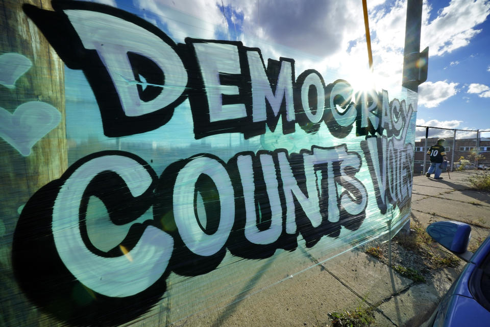 A sign saying Democracy Counts Votes hangs near the Allegheny County Election Division Warehouse on Pittsburgh's Northside where votes continue to be counted, Tuesday, Nov. 10, 2020. (AP Photo/Gene J. Puskar)