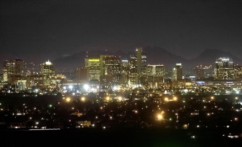 FILE - Piestewa Peak is seen behind the illuminated Phoenix skyline on February 28, 2002, from South Mountain in Phoenix. Eight of the 10 largest cities in the U.S. lost population during the first year of the pandemic, with only Phoenix and San Antonio gaining new residents from 2020 to 2021, according to new estimates released, Thursday, May 26, 2022, by the U.S. Census Bureau. (AP Photo/Mel Evans, File)