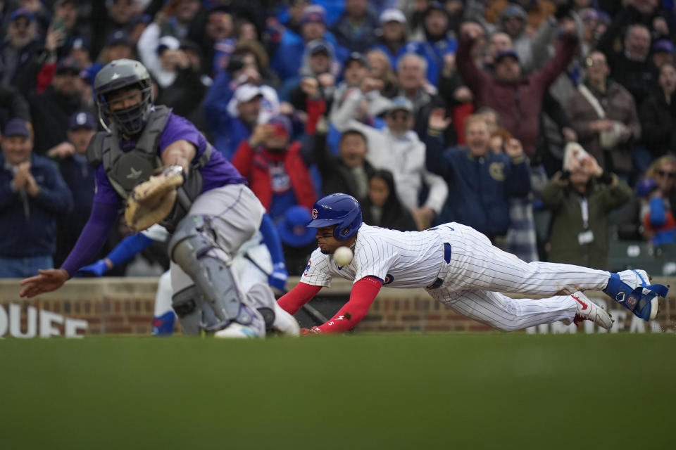 Chicago Cubs' Christopher Morel, right, slides into home past Colorado Rockies catcher Elias Diaz during the sixth inning of a baseball game, Monday, April 1, 2024, in Chicago. (AP Photo/Erin Hooley)