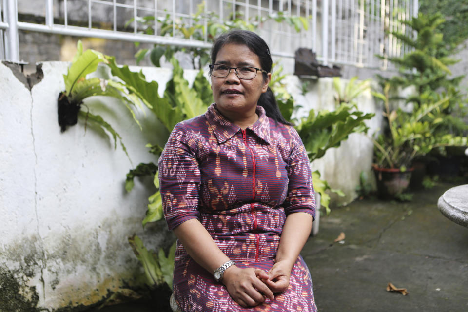 Bali bombing survivor Thiolina Marpaung poses for a photograph during an interview with The Associated Press in Denpasar in Bali, Indonesia, on Oct. 3, 2022. Marpaung was in a car with her colleagues on the Indonesian resort island of Bali in 2002 when a blast shook their vehicle from behind. Marpaung was temporarily blinded as shards of glass pierced her eyes. Marpaung still panics anytime she smells smoke, immediately recalling the bomb explosion that upended her life 20 years ago. (AP Photo/Firdia Lisnawati)