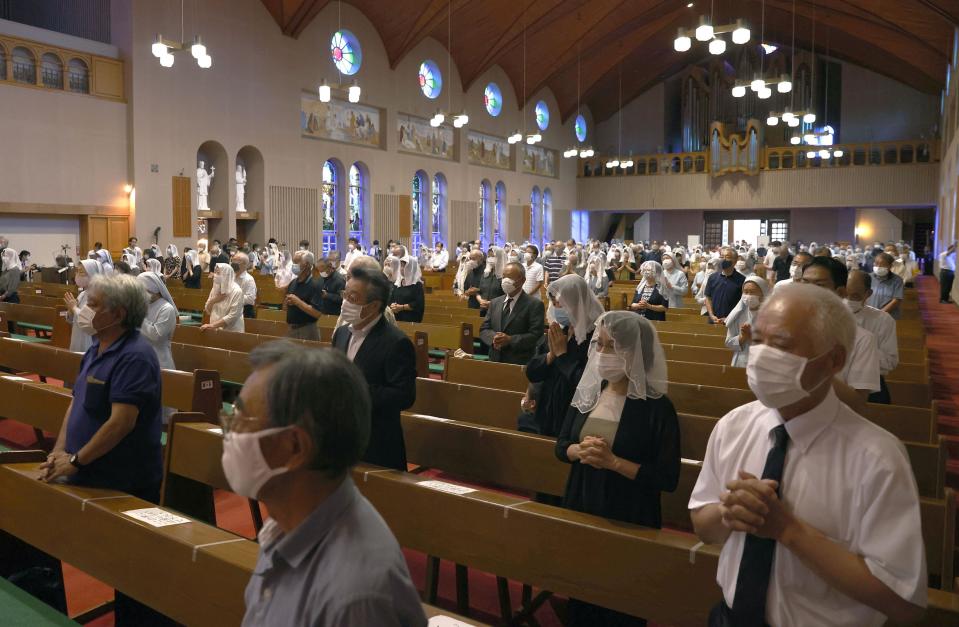 Christians, wearing face masks, pray for the victims of U.S. atomic bombing during a mass at Urakami Cathedral in Nagasaki, southern Japan, Sunday, Aug. 9, 2020. Nagasaki marked the 75th anniversary of the atomic bombing on Sunday. (Takuto Kaneko/Kyodo News via AP)