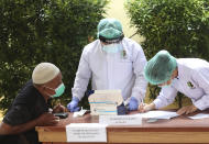 A relative of a passenger of a Sriwijaya Air jet that crashed into the sea, talks to Disaster Victim Identification (DVI) team at a hospital in Jakarta, Indonesia, Tuesday, Jan. 12, 2021. Indonesian navy divers were searching through plane debris and seabed mud Tuesday looking for the black boxes of the jet that nosedived into the Java Sea over the weekend with 62 people aboard. (AP Photo/Achmad Ibrahim)