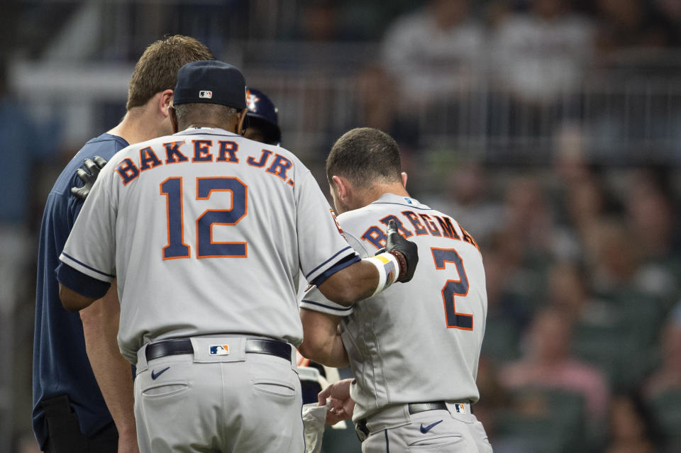 Houston Astros manager Dusty Baker Jr. and training staff check on Alex Bregman after being hit by pitch in the ninth inning of a baseball game against the Atlanta Braves Saturday, Aug. 20, 2022, in Atlanta. (AP Photo/Hakim Wright Sr.)