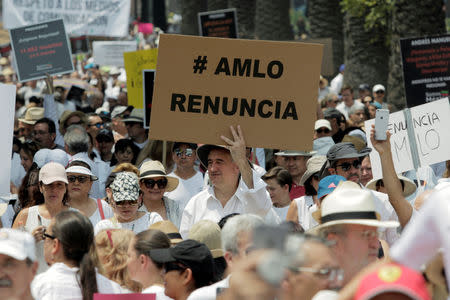A demonstrator holds a sign during a march against the government of Mexico's President Andres Manuel Lopez Obrador in Mexico City, Mexico May 5, 2019. The sign reads, "#AMLO resignation". REUTERS/Luis Cortes
