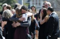 Friends and family hug after the funeral of Josh Hunter in Calgary, Alberta, April 21, 2014. Matthew de Grood is charged with killing Hunter and four of his friends at a house party in Calgary's worst mass murder in the history of the city, according to local media reports. REUTERS/Todd Korol (CANADA - Tags: CRIME LAW OBITUARY)