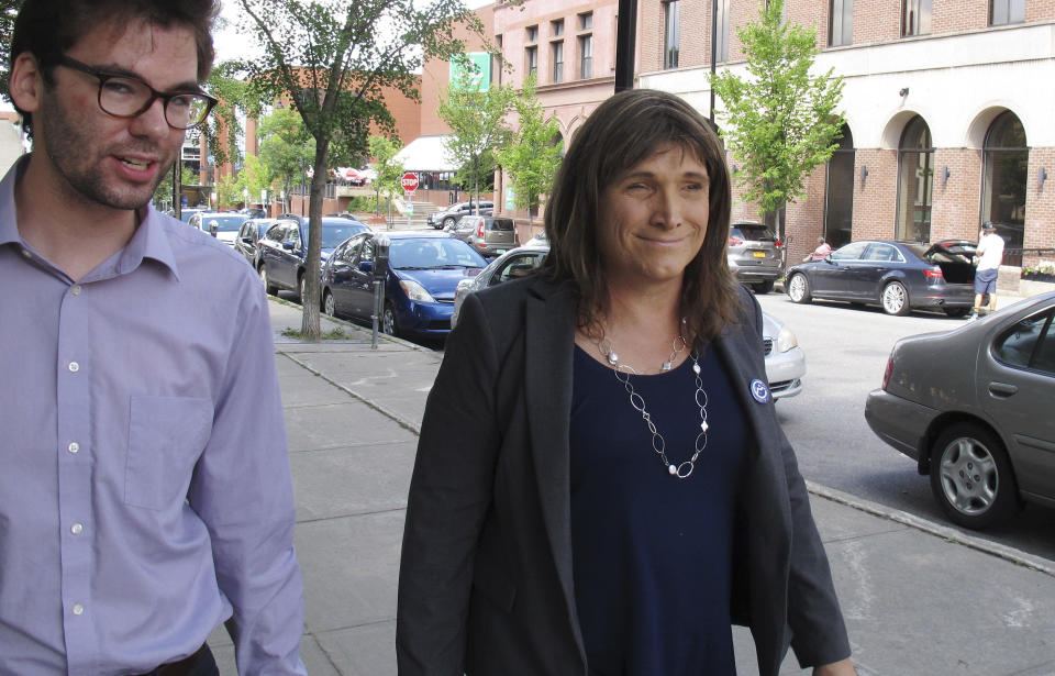 In this Aug. 9, 2018 photo, Christine Hallquist, transgender candidate seeking the Democratic party nomination to run for governor of Vermont, walks with campaign aide David Glidden in Burlington, Vt. Vermont's state primary election is scheduled for Tuesday, Aug. 14. (AP Photo/Wilson Ring)