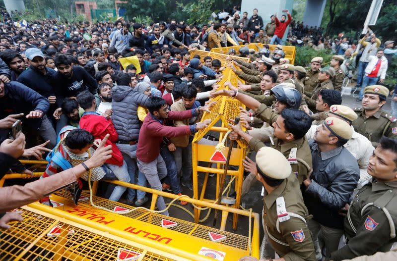 Police and students scuffle outside the Jamia Millia Islamia University during a protest against the Citizenship Amendment Bill in New Delhi