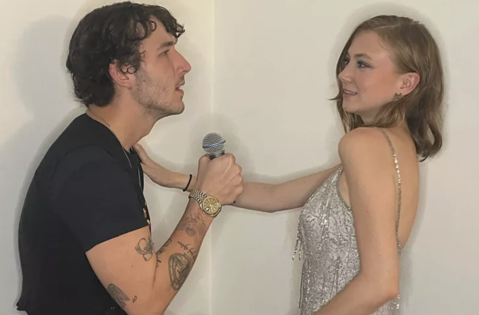 closeup of the couple with frankie holding a mic and anna in a sparkly dress