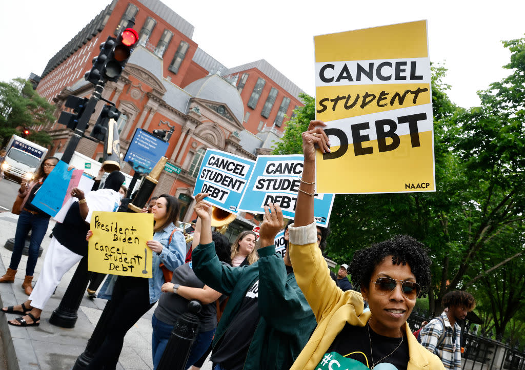 Student loan borrowers hold signs saying: Cancel Student Debt, NAACP.