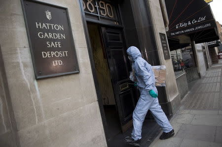 A police forensic officer enters a safe deposit building on Hatton Garden in central London April 7, 2015. REUTERS/Neil Hall