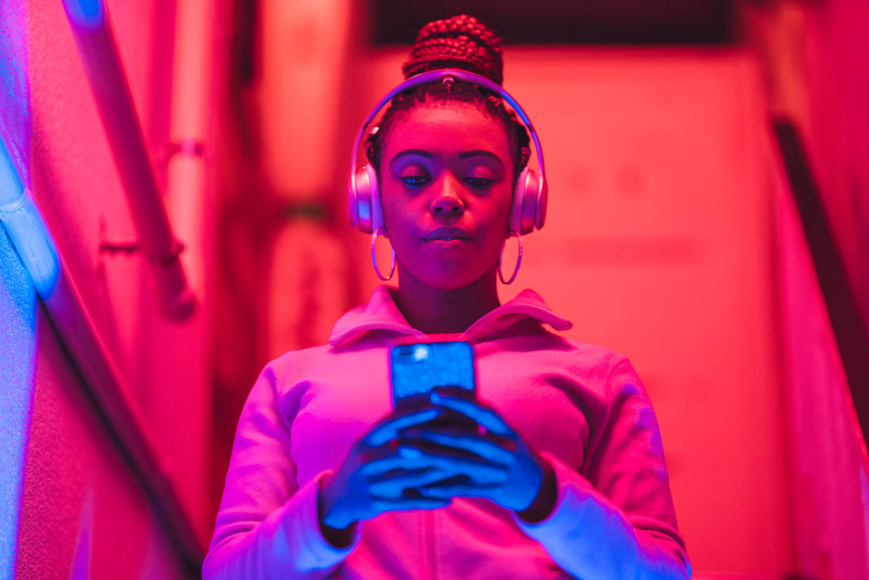 This woman listens to music on the go with her Bluetooth headphones. 