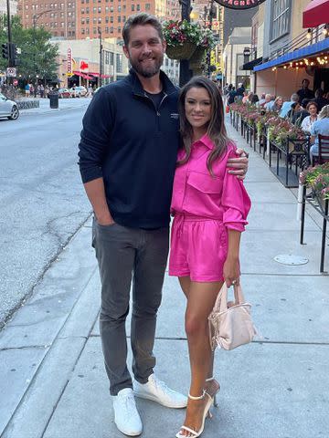 Taylor Mills Instagram Brett Young and Taylor Mills Young embrace while taking a picture on the sidewalk.