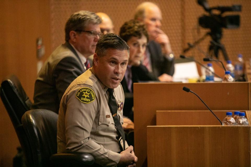 A deputy in uniform speaking on a witness stand