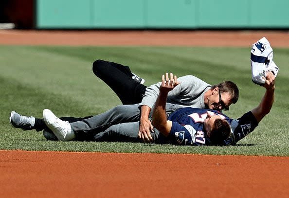 BOSTON, MA - APRIL 3: Rob Gronkowski #87 of the New England Patriots is tackled by Tom Brady #12 after stealing his jersey before the opening day game between the Boston Red Sox and the Pittsburgh Pirates at Fenway Park on April 3, 2017 in Boston, Massachusetts. (Photo by Maddie Meyer/Getty Images)