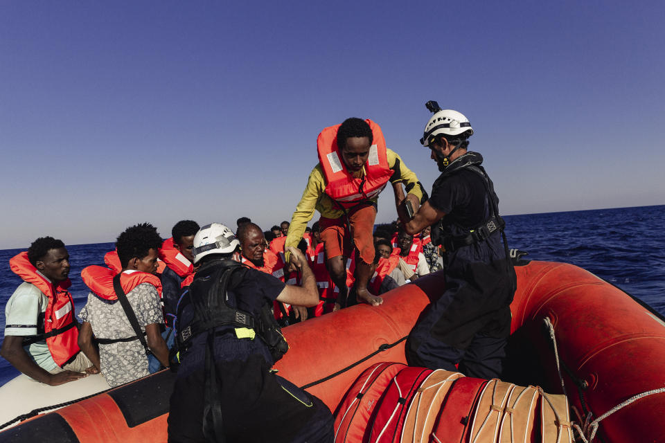 Crew of the Sea-Watch 3 evacuate people from a boat in distress in the central Mediterranean on Saturday July 23, 2022. Ships in the Mediterranean Sea have rescued over 1,100 people struggling to reach Europe in rickety smugglers boats and found five bodies. The Italian Coast Guard says Sunday that Italian vessels recovered the bodies Saturday as it rescued 674 people packed on a fishing boat adrift in the Mediterranean off the Libyan coast. (Nora Boerding/Sea-Watch via AP)