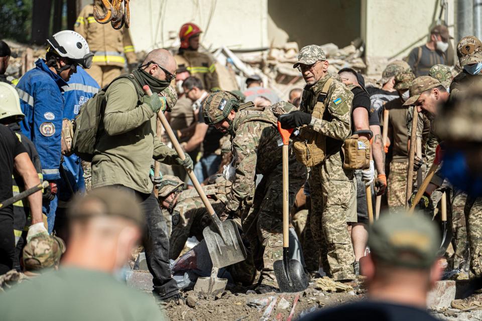 Rescue and military forces clear the rubble of the destroyed building with shovels