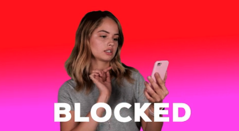 A woman with her phone and the word "BLOCKED"