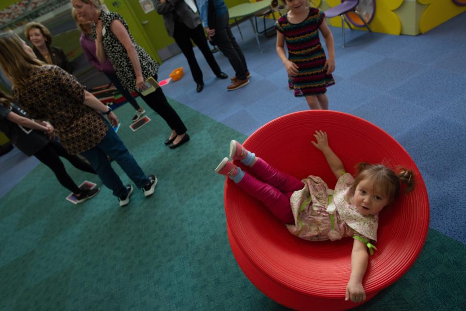 Eden Christensen spins around in a whirling chair at the Kansas Children's Discovery Center.