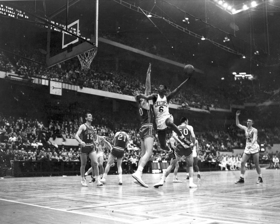 Bill Russell (6) Boston Celtics, goes up against defense Charlie Share (70), St. Louis Hawks, to score a basket in the first period of their National Basketball Association game at Boston Garden. Behind Russell is Hawks’ Ed Macauley (50). (AP Photo)