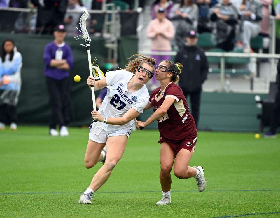 Izzy Scane (27) of Northwestern controls the ball in front of a Boston College defender during the 2023 NCAA women's lacrosse championship game at Wake Med Soccer Park.