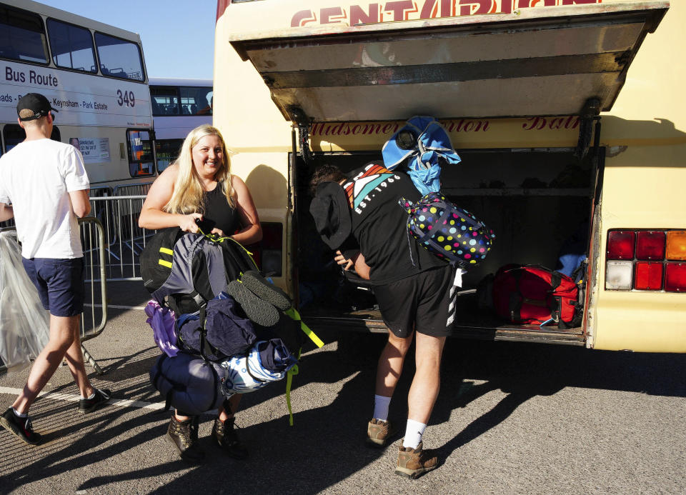 Gente aborda un autobús en la estación Castle Cary rumbo al Festival de Glastonbury en Worthy Farm, en Somerset, Inglaterra, el miércoles 22 de junio de 2022. (Ben Birchall/PA vía AP)