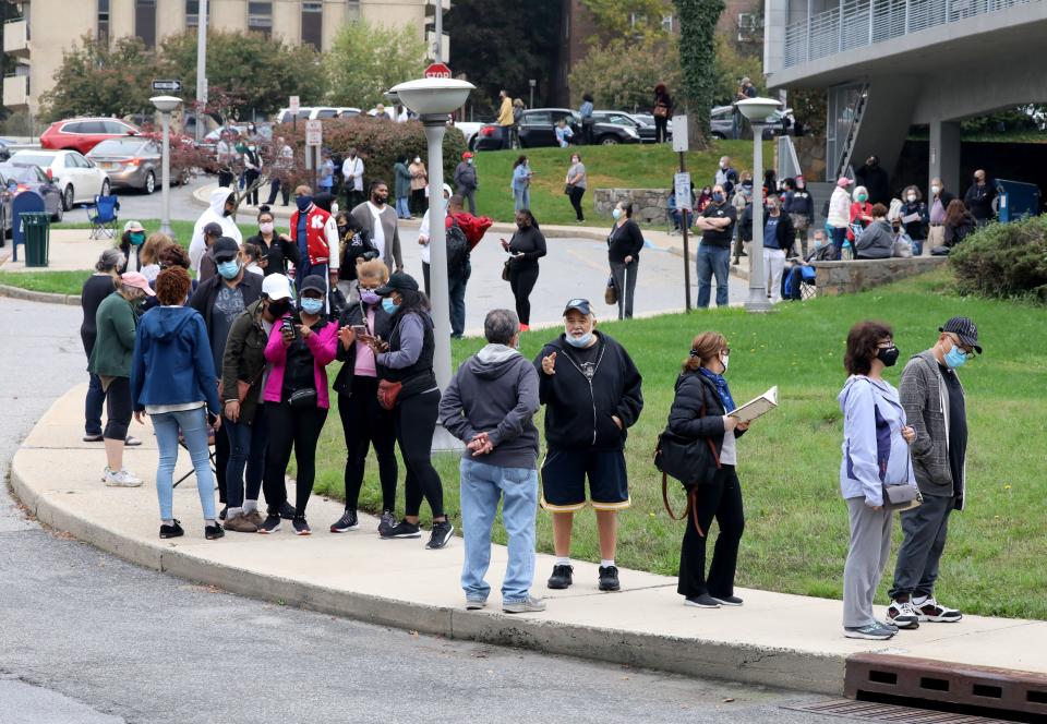 Voters line up in front of the Yonkers Public Library, Grinton I. Will Branch on Central Park Avenue, as the first day of early voting begins, Oct. 24, 2020. 