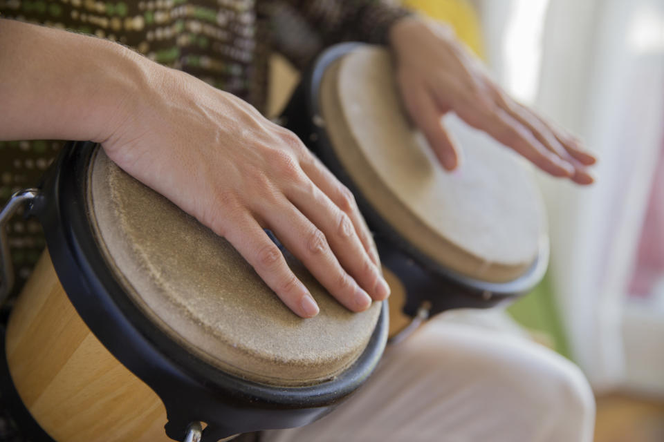 people's hands on a set of bongo drums