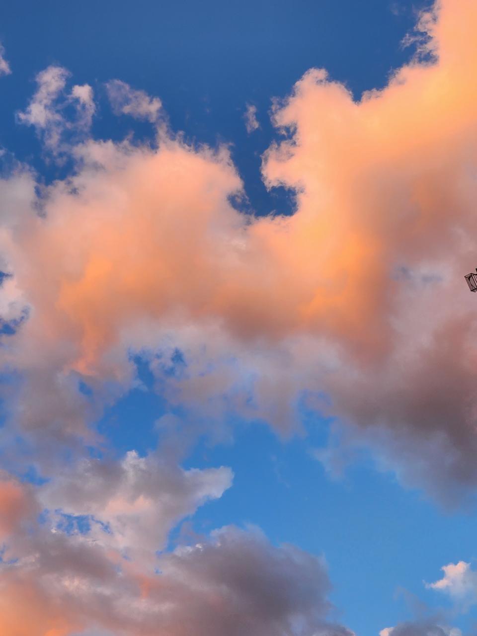 <p>A picture taken with the Galaxy Z Flip 4 showing some pink fluffy clouds in a blue sky.</p>
