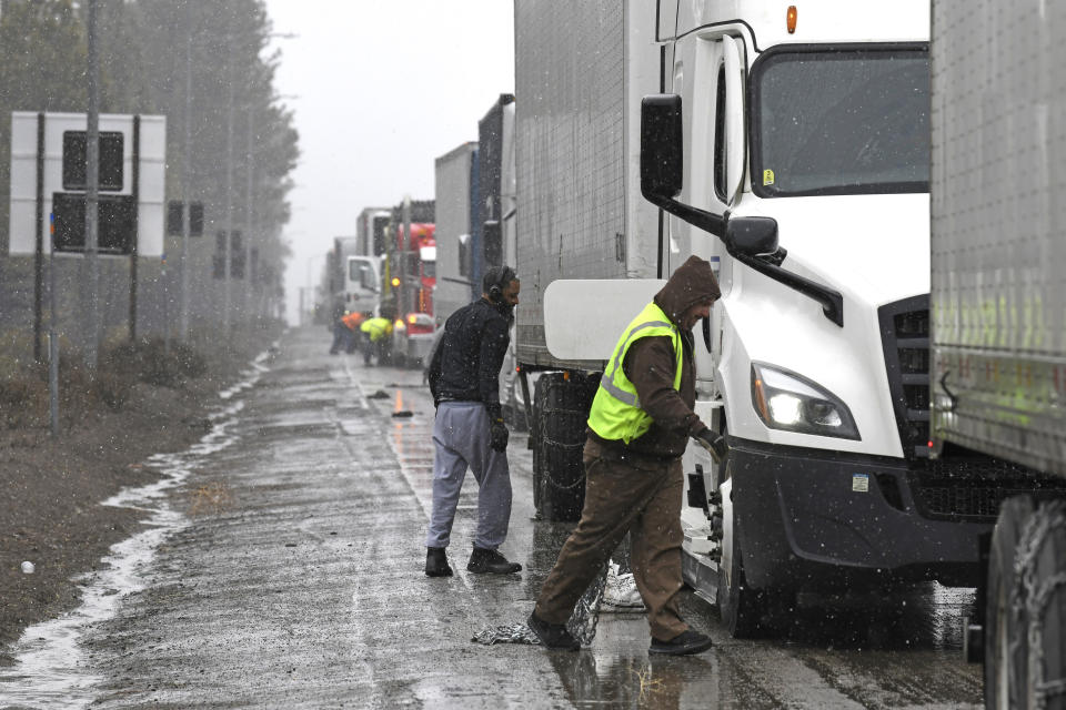 A long line of trucks are parked off the west bound I-80 as drivers put chains on the truck wheels in preparation for the snow storm over the Sierra Nevada on Thursday, Feb. 29, 2024, in Lake Tahoe, Calif. A Pacific storm packing powerful winds and heavy snow is shaping up to be the strongest of the season, forecasters say. (AP Photo/Andy Barron)